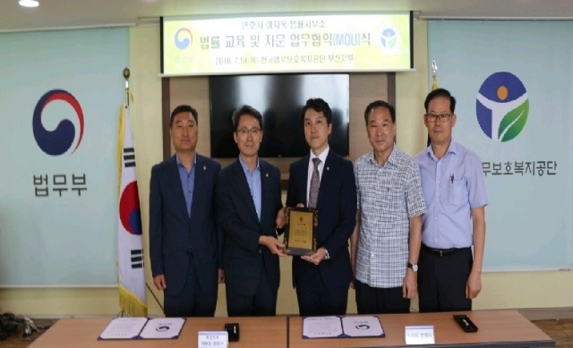 업무협약서를 내보이며 기념촬영을 하고있다.(사진제공=한국법무보호복지공단부산지부)