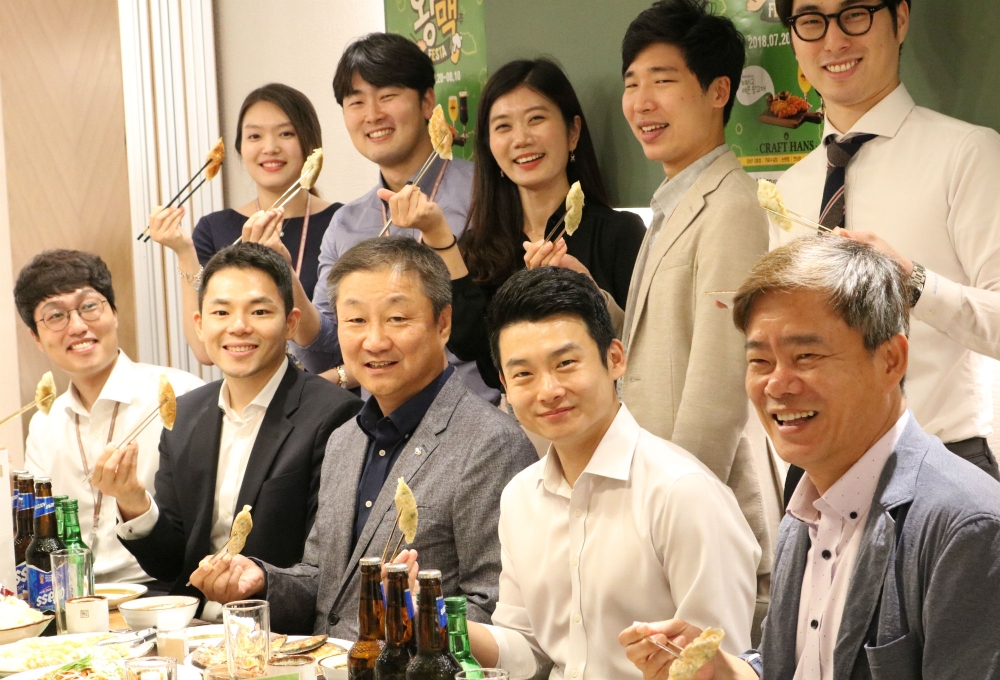 임직원간 소통 강화를 위해 모인 신현재 CJ제일제당 대표이사(아래 왼쪽에서 세번째)와 신영수 BIO인사지원실장(아래 오른쪽 첫번째), 열린협의회 소속 직원들이 비비고 왕교자를 들고 있다. (사진= CJ제일제당)