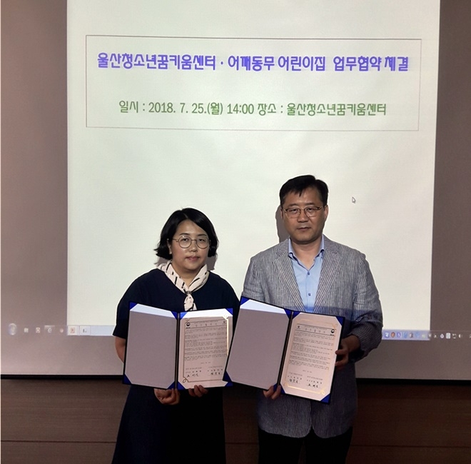 업무협약서를 내보이며 기념촬영을 하고 있다.(사진제공=울산청소년꿈키움센터)
