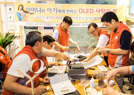LG디스플레이 OLED조명사업담당 박성수 상무(오른쪽에서 두번째)를 비롯한 임직원들이 미혼모를 위한 OLED수유등을 직접 제작하고있다. (사진=LG디스플레이)
