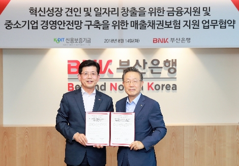 윤대희 신용보증기금 이사장(오른쪽)과 빈대인 부산은행 은행장이 14일 부산은행 본점에서 열린 혁신성장・일자리 창출 금융지원 및 매출채권보험 활성화 업무협약에서 기념촬영을 하고 있다. (사진=신용보증기금)