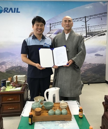창원 성주사 주지스님과 업무협약서를 내보이며 기념촬영. (사진제공=코레일부산경남본부)