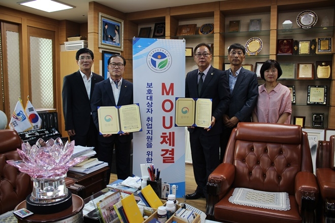 업무협약서를 내보이며 기념촬영을 하고 있다.(사진제공=한국법무보호복지공단울산지부)