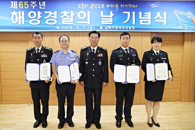해양경찰의 날 기념행사에서 김홍희 남해해경청장(사진가운데)이 유공자 포상을 받은 직원과의 기념촬영을 하고 있다.(사진제공=남해지방해양경찰청)