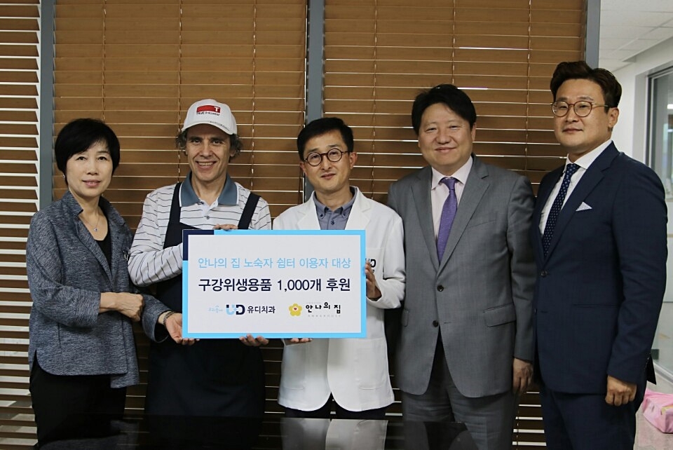 왼쪽부터 오현숙 안나의 집 사무국장, 김하종 안나의 집 신부, 백영걸 용인동백 유디치과의원 대표원장, 김종명 ㈜유디 사장, 이경환 ㈜유디 홍보 기획팀 차장이 구강건강용품 후원 전달식을 기념해 사진촬영 하는 모습. (사진=유디치과)