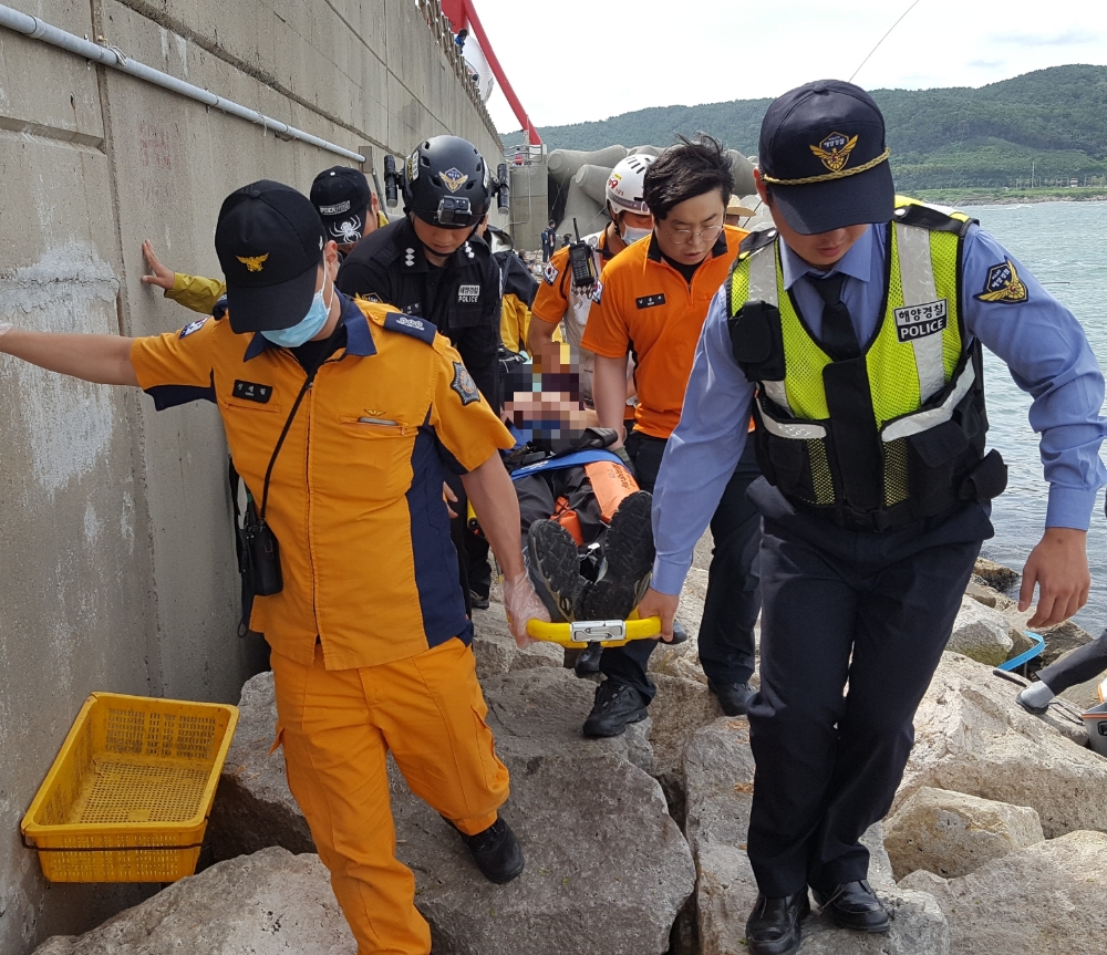 낙상환자를 소방과 해경이 합동으로 구조해 옮기고 있다.(사진제공=울산해양경찰서)
