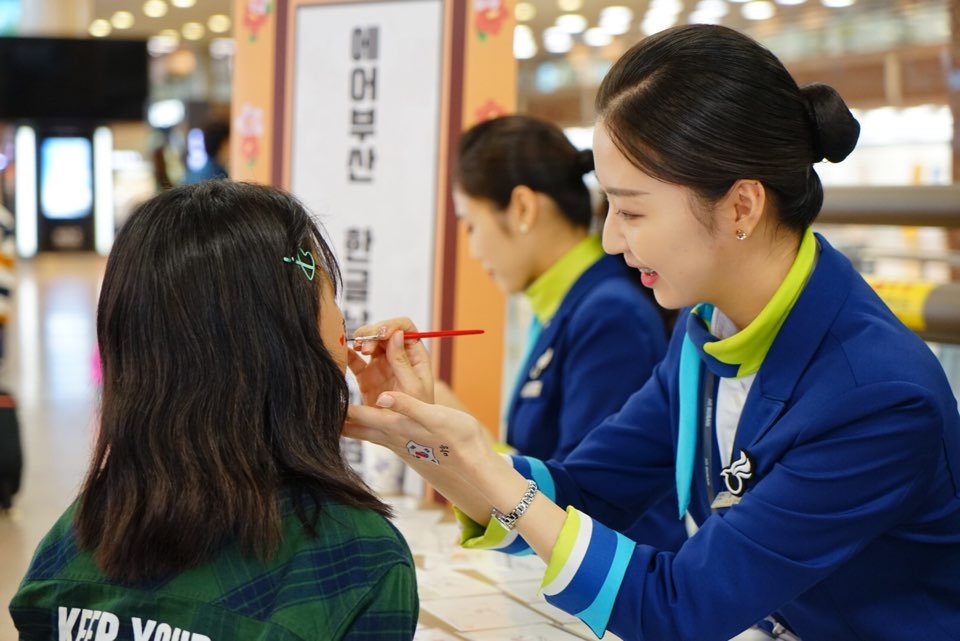 에어부산 승무원이 어린이에게 페이스페인팅을 해주고 있다.(사진제공=에어부산)