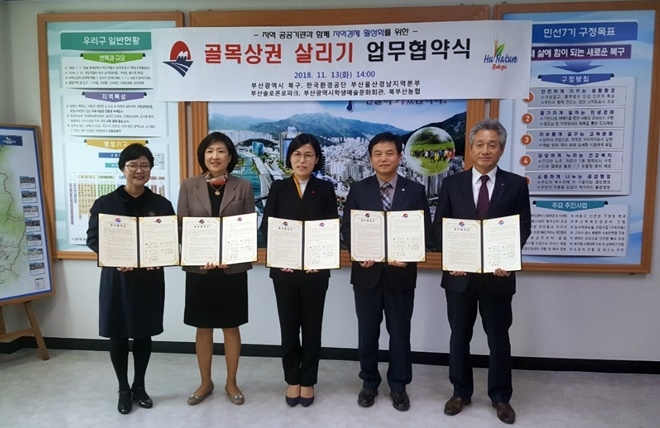 북구청 집무실에서 골목상권 살리기 업무협약서를 내보이며 기념촬영.(사진제공=부산솔로몬로파크)