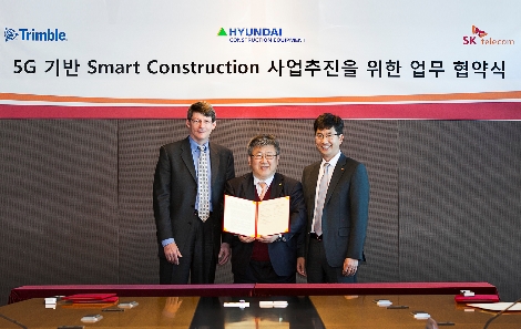 SK텔레콤 최판철 영업본부장(사진 오른쪽), 현대건설기계 김대순 부사장(가운데), 트림블 마이클 그랜루스(Michael Granruth) OEM 엔지니어링 총괄이 기념 촬영을 하고 있는 모습.(사진=SK텔레콤)