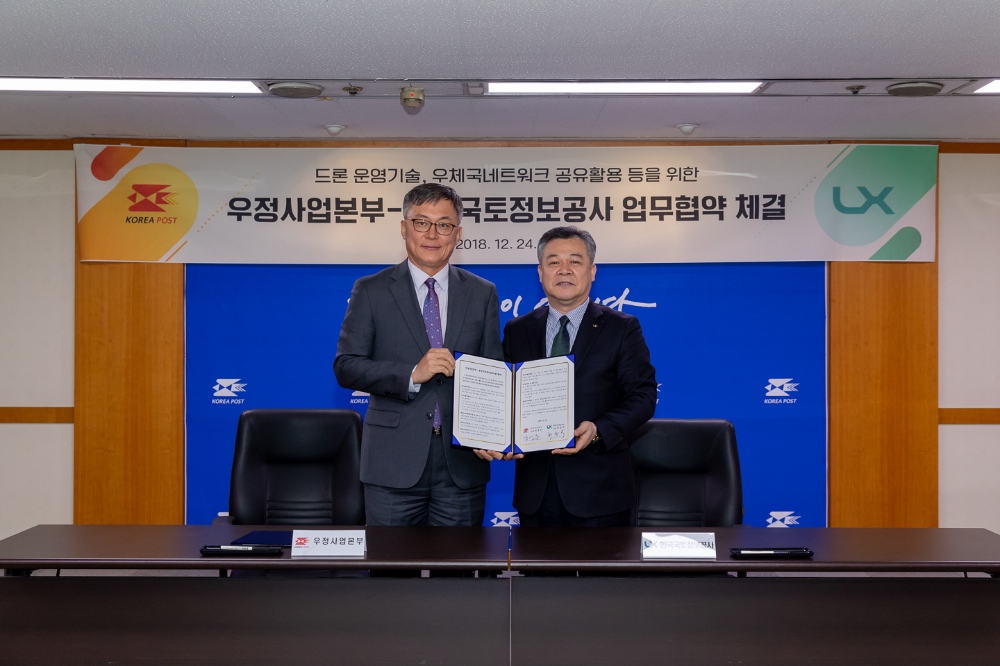 업무협약 체결 후 기념촬영을 하고 있는 최창학LX사장(우)과 강성주 우정사업본부장(좌). (사진=LX)