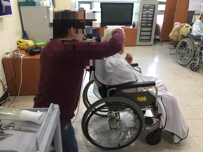 미용특기 사회봉사대상자가 어르신 머리를 손질하고 있다.(사진제공=거창준법지원센터)
