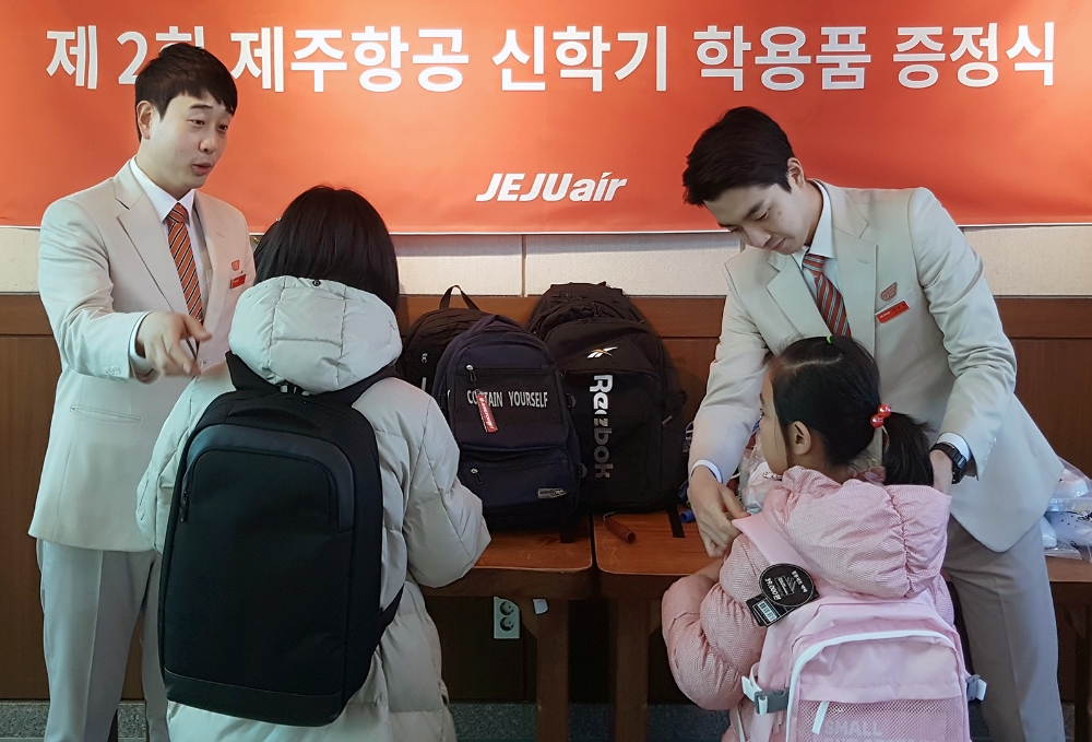 지난 7일 제주항공 객실승무원들이 제주보육원 어린이들에게 새학기 준비물을 전달하고 있다. (사진=제주항공)