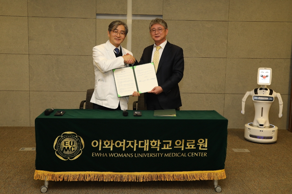 문병인 이화여자대학교 의무부총장 겸 의료원장(사진 왼쪽)과 김덕준 ㈜로보케어 대표이사(사진 오른쪽)이 업무 협약 체결 후 기념촬영을 하고 있다. (사진=이화의료원)