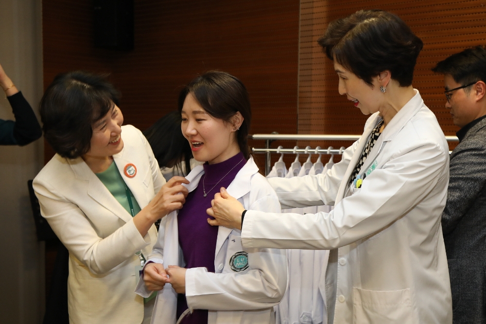 이선영 진료부원장과 현석경 간호부원장이 신입 인턴에게 의사 가운을 입혀주고 있다. (사진=이대목동병원)