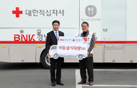 BNK경남은행황윤철 은행장(사진 왼쪽)이 대한적십자사 경남지사 김종길 회장에게 ‘이동 급식차량 기증서’를 전달하고 있다. 사진=BNK경남은행