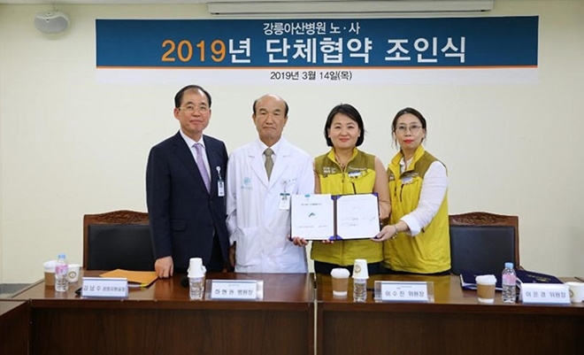 강릉아산병원 노사는 조합 활동을 보장하고 노동조건 개선 내용이 담긴 단체협약을 체결하고 기념촬영.(사진제공=의료노련)
