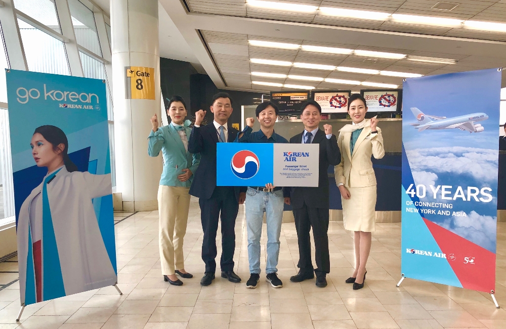 행운의 주인공 류주성씨(가운데)가 대한항공 정병섭 뉴욕여객지점장(오른쪽에서 두 번째), 심종헌 뉴욕공항지점장(왼쪽에서 두 번째), 객실승무원과 기념촬영을 하는 모습. (사진=대한항공)