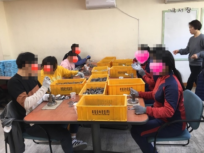 재원생들이 장애인들과 더불어 손톱깎이 조립 및 케이스포장을 하고 있다.(사진제공=정심여자중고등학교)