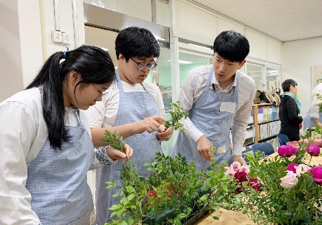 한화투자증권 직원과 국제서울농학교학생이 함께 꽃으로 작품을 만들고 있다. 사진=한화투자증권