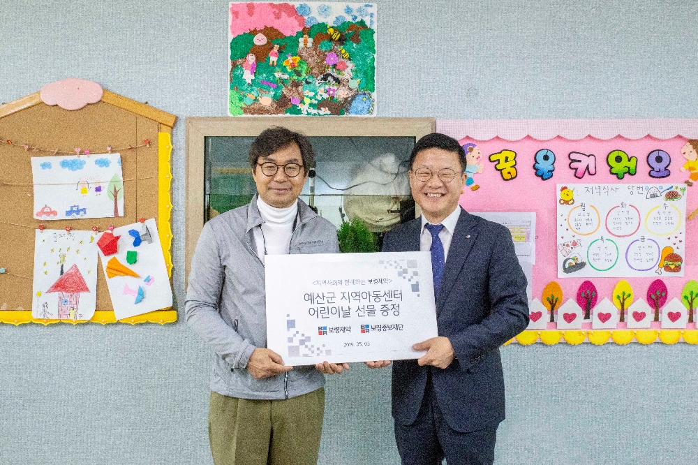 3일 예산군 다운지역아동센터에서 진행된 ‘어린이날 선물 증정식’에서 사회복지법인 보령중보재단 남흥수 사무국장(오른쪽)과 예산군 지역아동센터협의회 김동경 다운지역아동센터장(왼쪽)이 기념사진을 찍고 있다. (사진=보령제약)