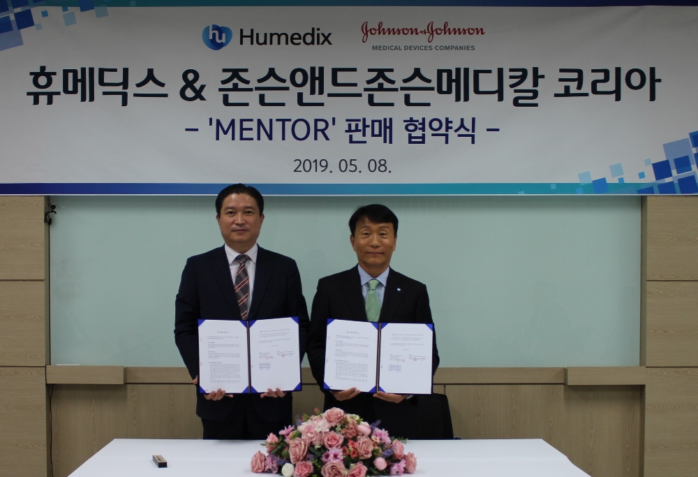 지난 8일 휴메딕스 안양 본사에서 휴메딕스 정구완 대표(사진 우측)와 존슨앤드존슨메디칼 코리아 정형근 상무(사진 좌측)가 가슴보형물 브랜드 ‘멘토’의 판매 계약을 체결했다. (사진=휴온스)