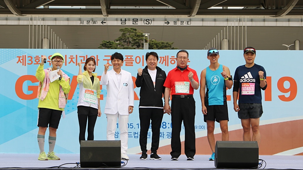 왼쪽부터 방송인 MC프라임, 탤런트 남보라, 진세식 유디치과 협회장, 김종명 ㈜유디 사장, 김천수 (사)굿피플인터내셔널, 가수 션, 은총이 아빠 박지훈이 마라톤 출발 전 파이팅 하고 있는 모습. (사진=유디치과)