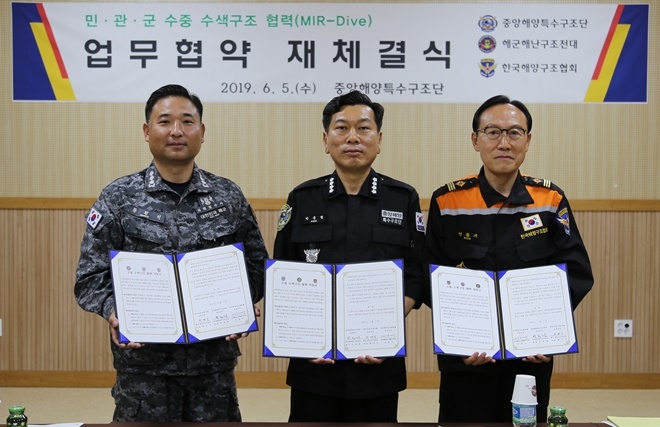 (사진왼쪽부터)황병익 해군 해난구조전대장(대령), 박종철 중앙해양특수구조단장(총경), 민홍기 한국해양구조협희 이사장이 업무협약서를 내보이며 기념촬영.(사진제공=중앙해양특수구조단)