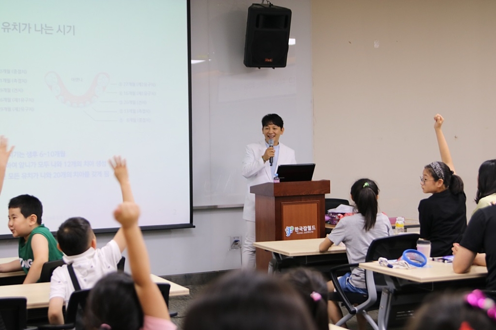 진세식 유디치과 협회장이 행사에 참석한 아동 및 청소년을 대상으로 구강건강교육을 실시하고 있는 모습. (사진=유디치과)