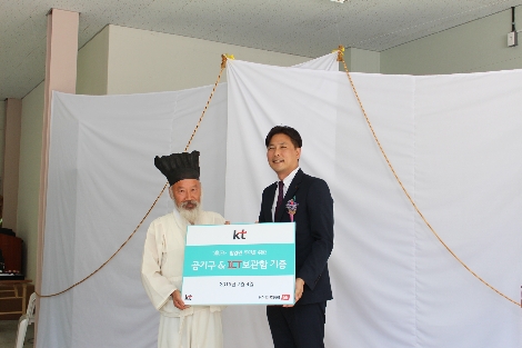 KT 지속가능경영담당 정명곤 상무(오른쪽)와 마을주민 은희장씨가 ICT 기반 공기구 무인 공유센터 ‘뚝딱뚝딱 공구소’ 개소식에서 공구소 기증서를 교환하고 있다. 사진=KT
