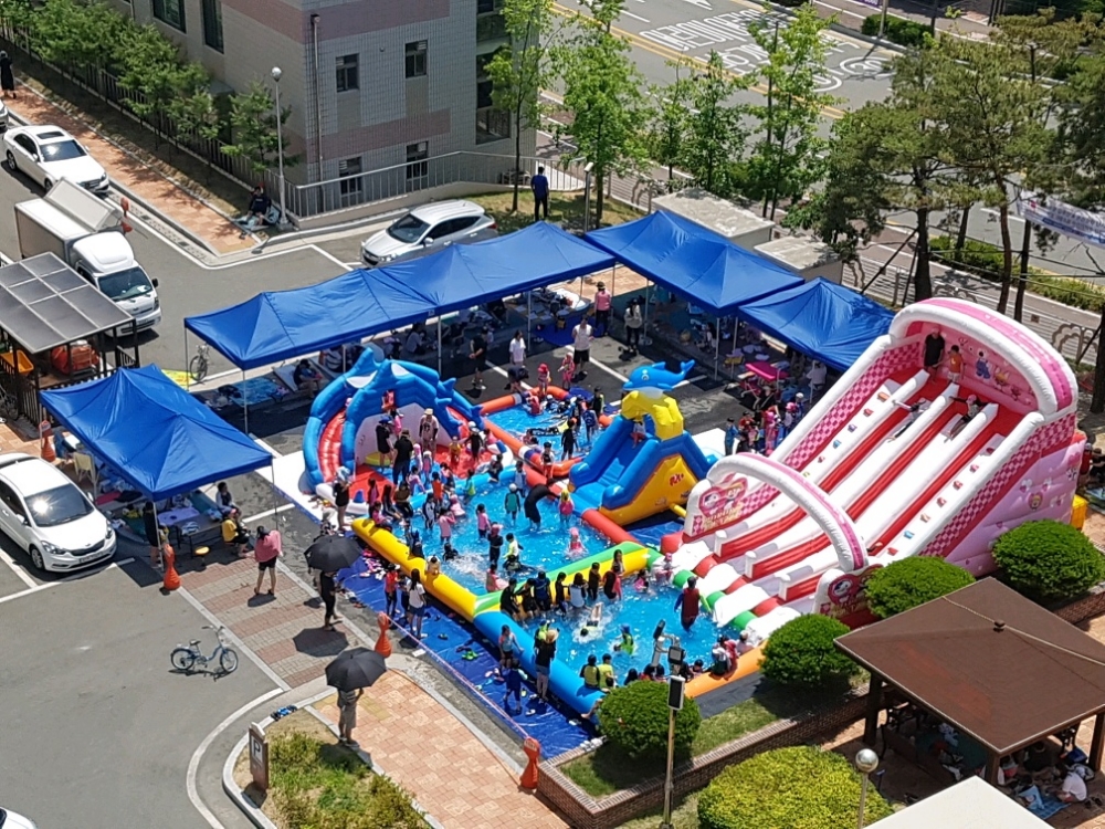 춘천장학 부영아파트 내에 설치된 이동형 워터파크 시설에서 아파트 입주자들과 부영 사랑으로 어린이집 원아들, 학부모들이 어울려 물놀이를 하는 모습.(사진=부영그룹)