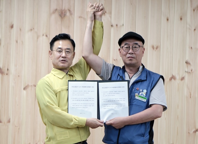 7월 11일 금정구 노포차량기지에서 이종국 부산교통공사 사장(왼쪽)과 최무덕 부산지하철노조 위원장이 '부산교통공사 노사 파업철회·잠정합의 선언'을 하고 손을 맞잡고 있다.(사진제공=부산지하철노조)