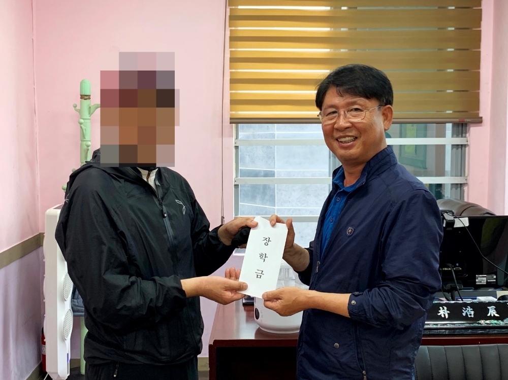 박호진 지부장이(사진우측) 만학도 보호대상자에게 기부받은 장학금을 전달하고 있다.(사진제공=한국법무보호복지공단부산지부)
