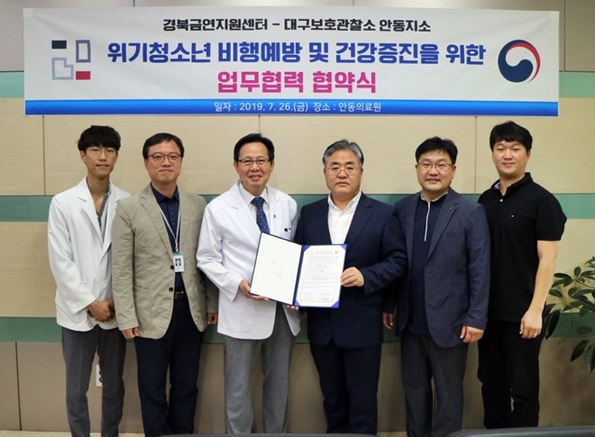 유정호 소장(사진우측 세번째)과 이윤식 센터장 등이 업무협약서를 내보이며 기념촬영.(사진제공=안동준법지원센터)