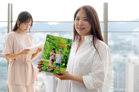 KT 직원들이 UN 지속가능발전목표(SDGs)와 연계된 KT의 지속가능경영 성과를 담은 2018 KT 통합보고서를 보고 있다. 사진=KT