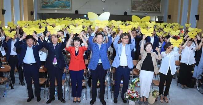 <기억하겠습니다>라는 문구가 적힌 노란색 나비모양 카드를 들어올리고 있다.(사진제공=경남도)