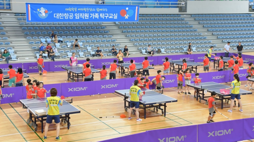 탁구교실에 참가한 임직원 자녀들이 대한항공 탁구단 선수들로부터 강습을 받고 있는 모습.(사진=대한항공)