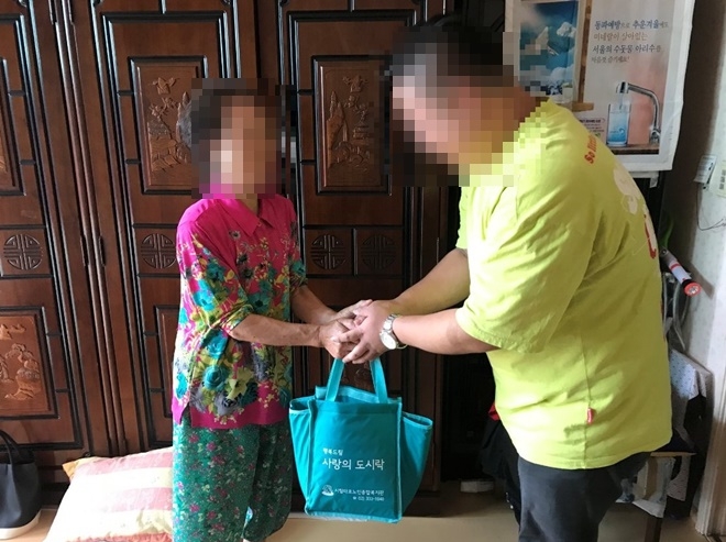 사회봉사대상자가 사랑의 도시락을 전달하고 있다.(사진제공=서울서부준법지원센터)