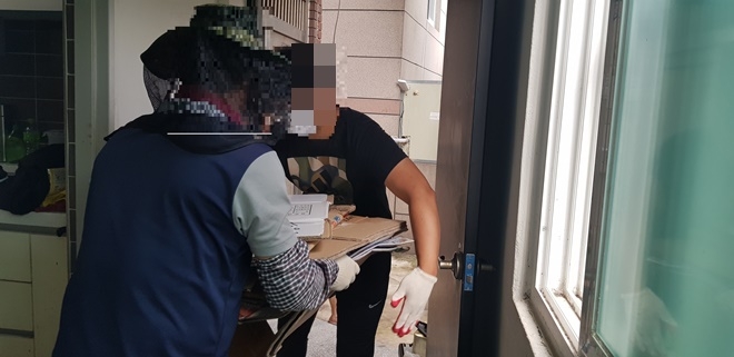 사회봉사명령대상자들이 장애인 한부모 가구에서 폐지 등을 치우고 있다.(사진제공=부산준법지원센터)
