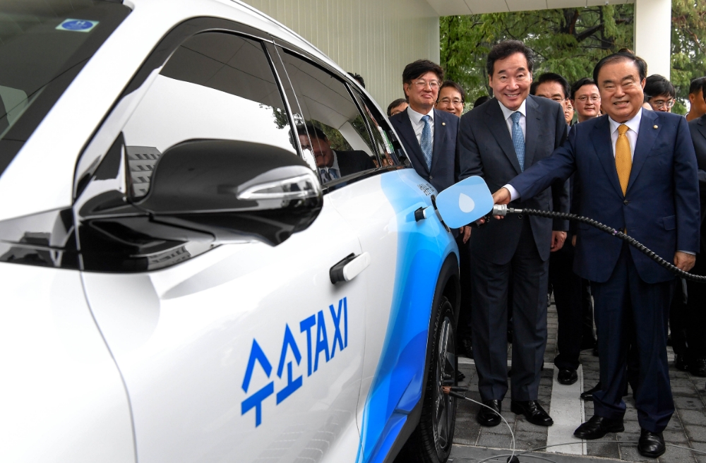 앞줄 오른쪽부터 문희상 국회의장, 이낙연 국무총리가 수소전기택시에 수소를 충전을 하는 모습.(사진=현대자동차)