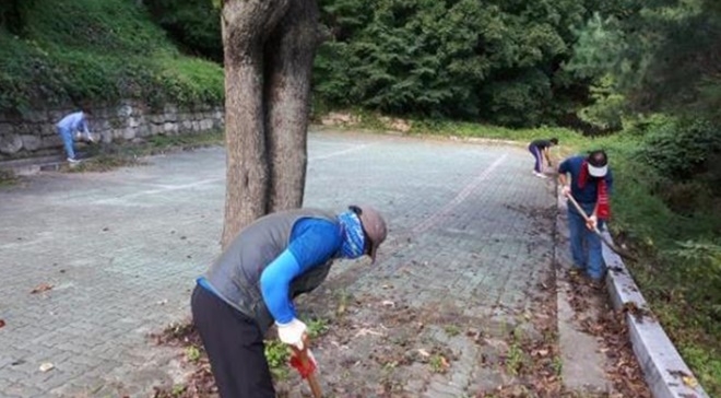 사회봉사대상자들이 도리사 주차장 환경정비 작업을 하고 있다.(사진제공=구미준법지원센터)