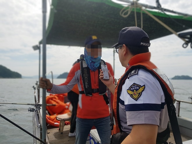해경이 낚시어선 승객을 대상으로 음주측정을 하고 있다.(사진제공=남해지방해양경찰청)