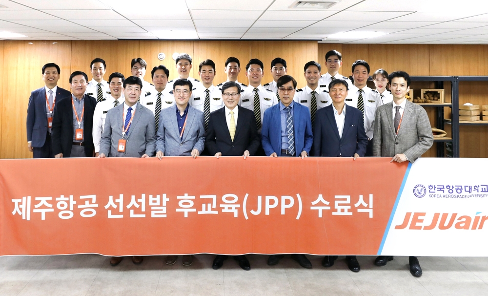 (앞줄 왼쪽부터)제주항공 한상훈 운항본부장, 이석주 대표이사, 한국항공대학교 이강웅 총장, 장형삼 비행교육원장 등이 수료식에서 12명의 수료자들이 기념사진을 찍고 있다.(사진=제주항공)