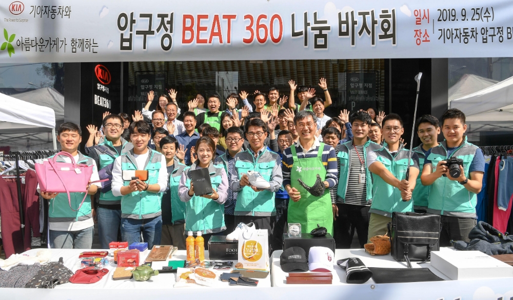 기아자동차 국내사업본부장 권혁호 부사장(앞줄 왼쪽에서 네 번째), 사회적기업 ‘아름다운가게’ 윤여영 상임이사(앞줄 왼쪽에서 다섯 번째) 등 기아자동차 임직원들과 아름다운가게 관계자들이 ‘압구정 BEAT360 나눔 바자회’ 시작을 알리며 기념촬영을 하고 있는 모습.(사진=기아자동차)