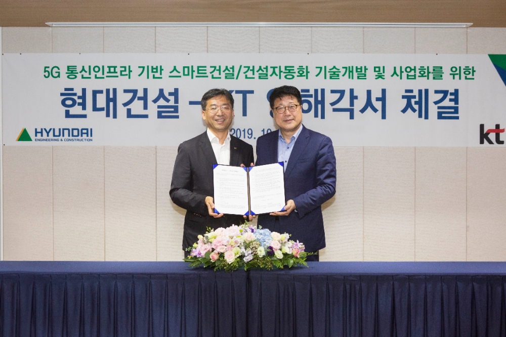 현대건설 R&D센터장 이석홍 전무(오른쪽)와 KT 네트워크전략본부장 서창석 전무(왼쪽)가 스마트 건설·건설자동화 기술개발 및 사업화를 위한 업무 협약을 맺고 기념촬영을 하고 있다.(사진=현대건설)