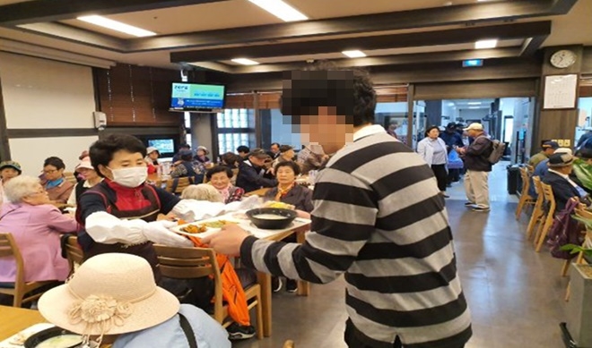 사회봉사 대상자가 어른신들의 점심을 챙기고 있다.(사진제공=서울서부준법지원센터)