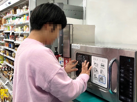 한 시각장애인 고객이 GS25 매장 내 전자레인지에 부착된 점자안내문을 읽고 있다. 사진=GS리테일