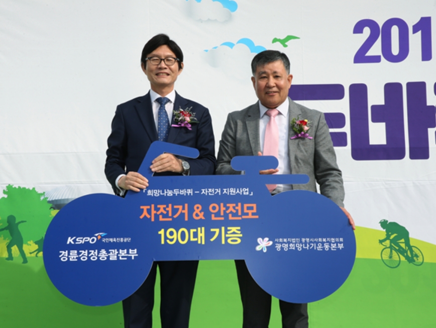 정병찬 경륜경정총괄본부장(왼쪽)이 이상재 광명시 사회복지협의회 회장에게 자전거와 안전모를 전달하고 있다.(사진=국민체육진흥공단)