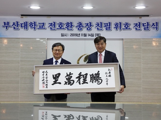 전호환 총장이 붕정만리 친필휘호를 최재호 회장에게 전달하고 기념촬영.(사진제공=무학)