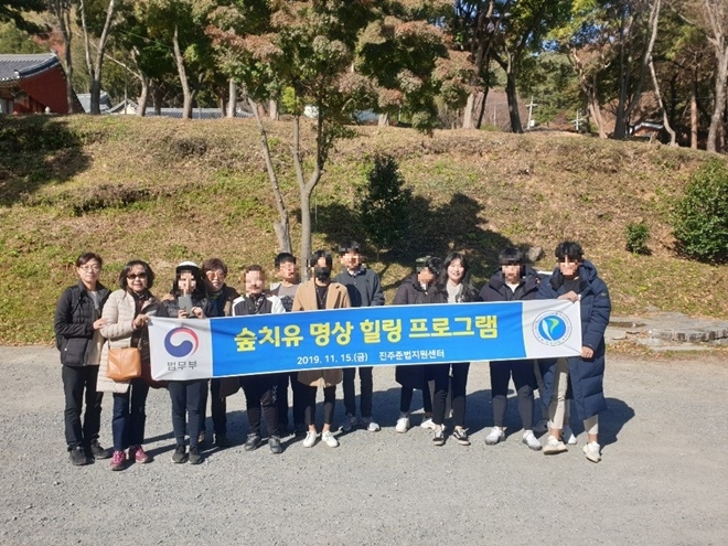 사천 봉명산 시립공원에서 숲치유 명상 힐링 프로그램에 참여하고 있는 청소년들이 보호관찰위원들과 기념촬영.(사진제공=진주준법지원센터)