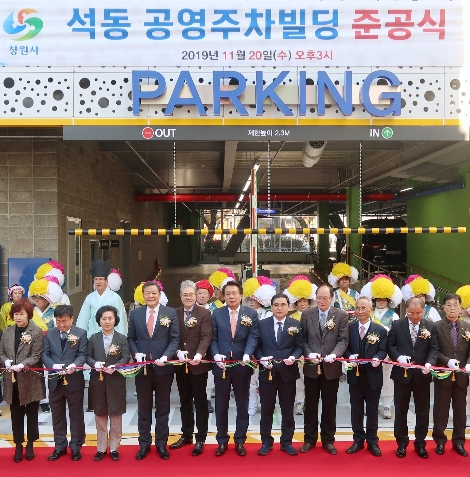 20일 오후 3시 창원시 석동 공영주차빌딩 부지에서 천정우 캠코 가계지원본부장(왼쪽에서 여섯번째), 허성무 창원시장(왼쪽에서 일곱번째) 및 관계자들이 '창원시 석동 공영주차빌딩 준공식'에서 테이프커팅을 하고 있다. 사진=캠코